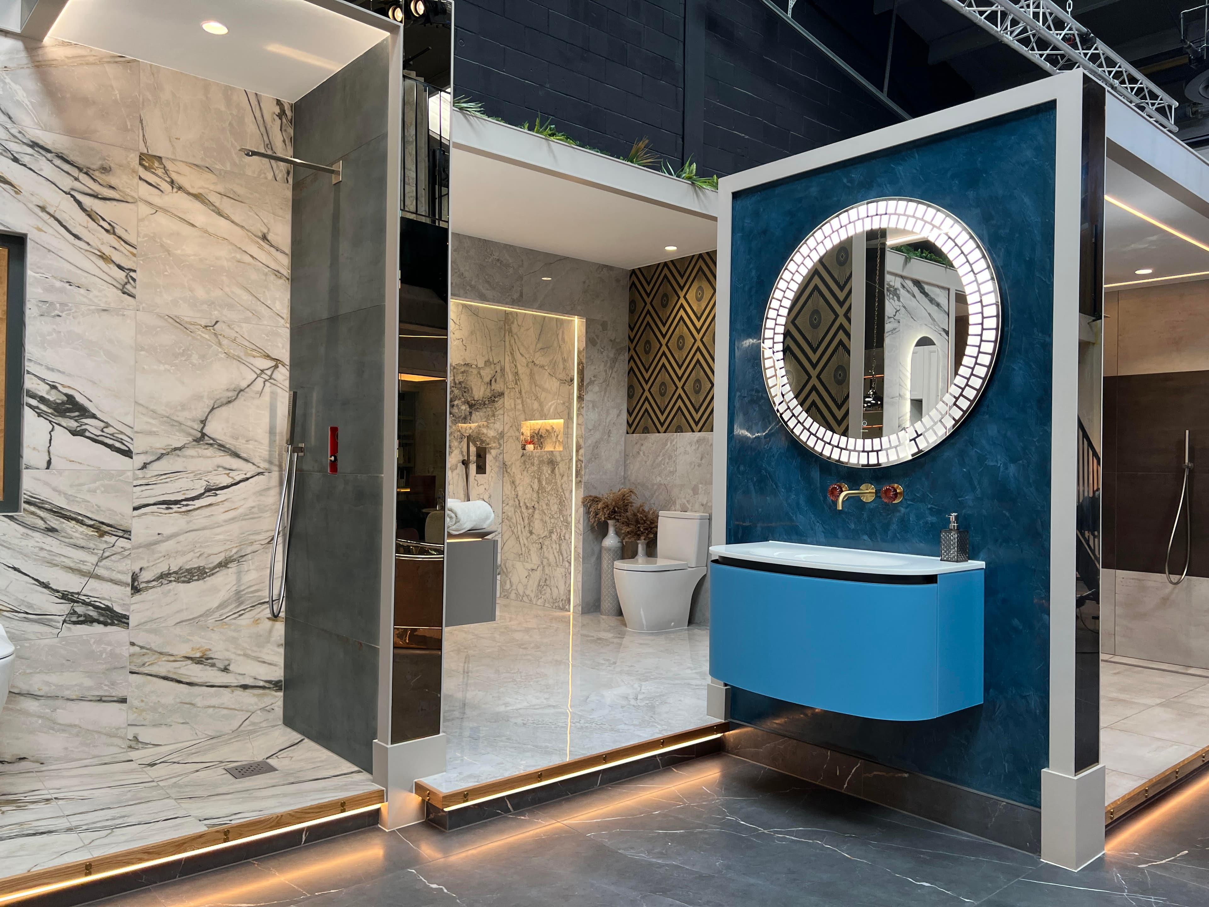 Bathroom atelier display pairing stone slabs and brushed brass fixtures.