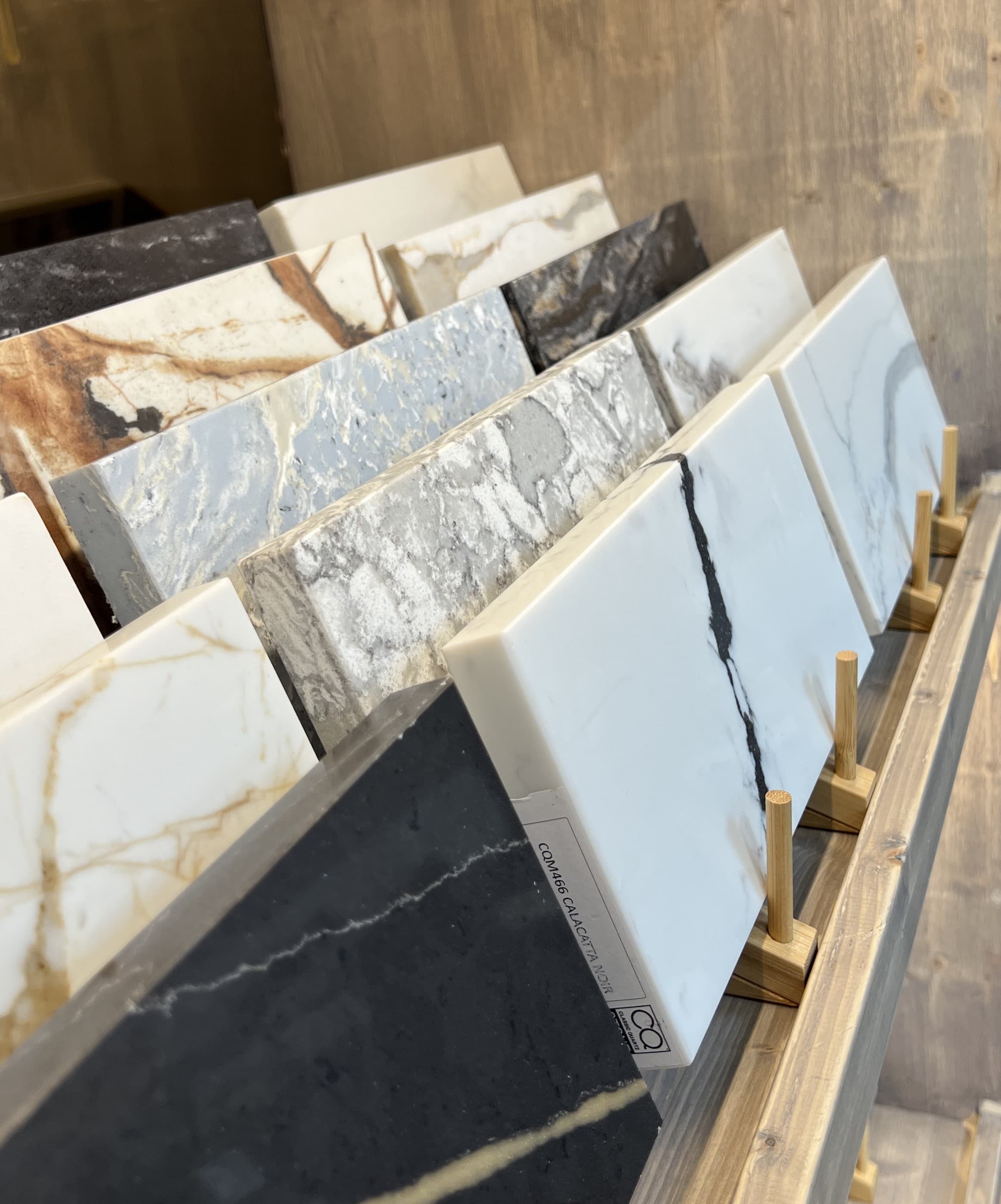 A curated wall of natural stone and timber samples in the showroom.